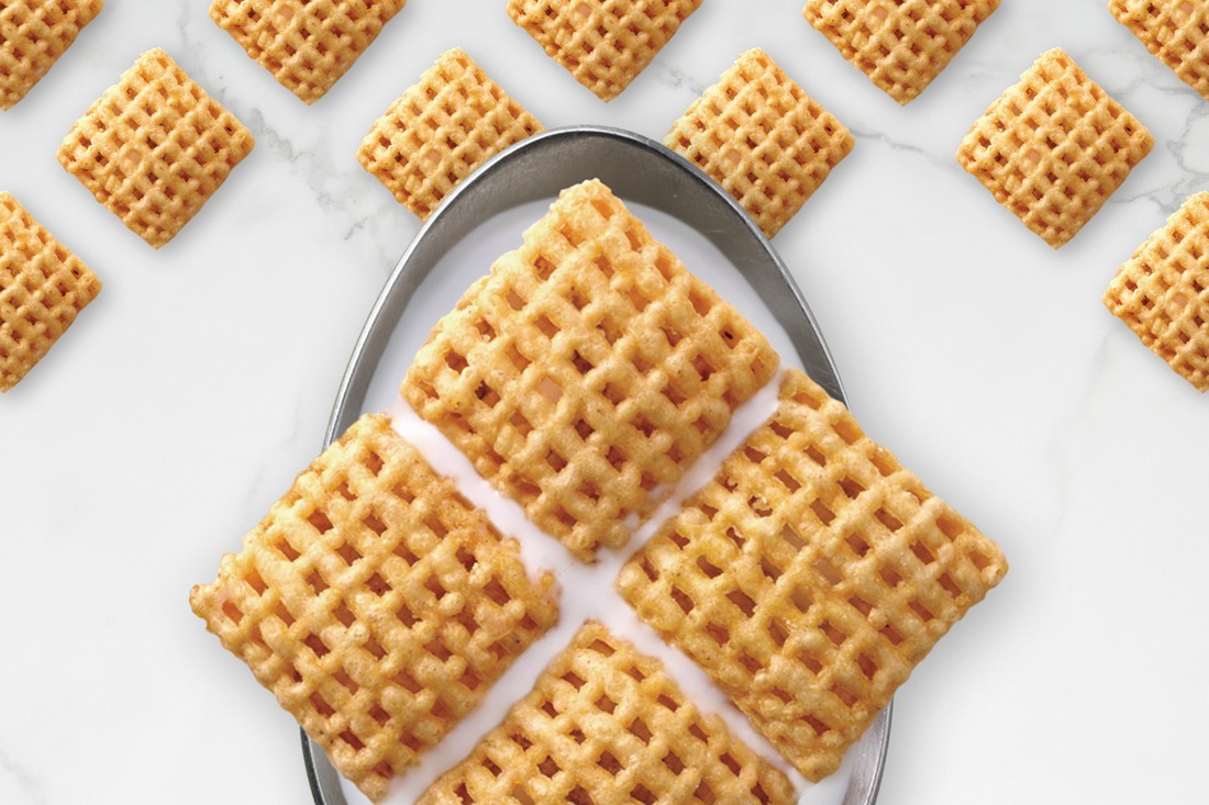 Chex cereal arranged in a diamond on a spoon with and organized Chex pieces pattern underneath